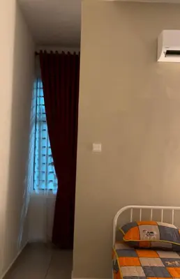 a bedroom with a bed and a window with red curtains at Homestay Sakura in Padang Serai