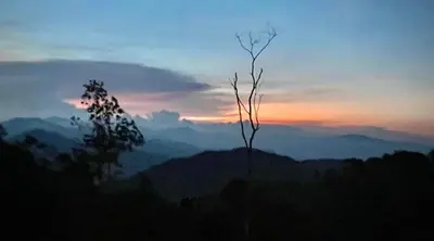a silhouette of a mountain with a sunset in the background at FHCOMFYHOME B33A1 At SILVERPARK RESORT in Bukit Fraser