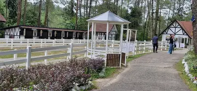 a white fence with a gazebo and people walking down a path at FHCOMFYHOME B33A1 At SILVERPARK RESORT in Bukit Fraser