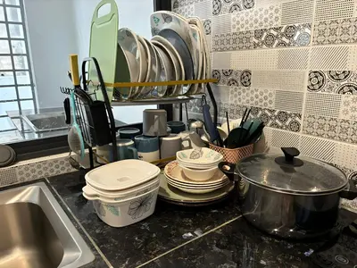 a kitchen counter with dishes and a sink at Serene Terrace House 2-12pax &Sunrise View in Brinchang