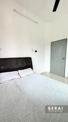 a bedroom with a bed with a black headboard and a door at SERAI Homestay in Gopeng