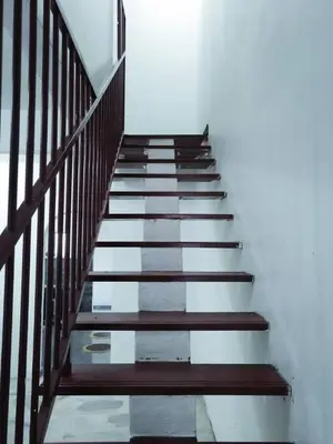 a staircase with wooden railings in a white room at SK Sweet Homestay SP Kedah in Sungai Petani