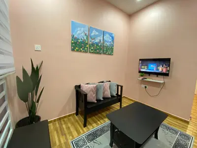 a living room with a couch and a tv at Yellow Retreat House Homestay Batu Gajah in Batu Gajah