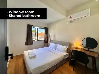 a bedroom with a bed and a desk and a window at Li's Inn in George Town