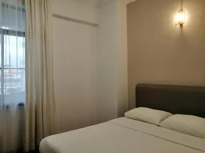 a bedroom with a bed and a window with a light at City Tropical Home II in George Town