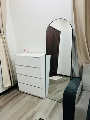 a dresser and mirror in a room with a chair at Inap Kasih Homestay Gua Musang Bandar Utama - Free Wifi, Netflix, Coway Provided in Gua Musang