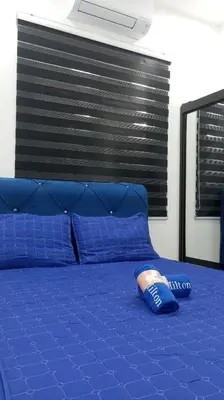 a blue bed with a blue head board and blue pillows at Affan Homestay in Seri Iskandar