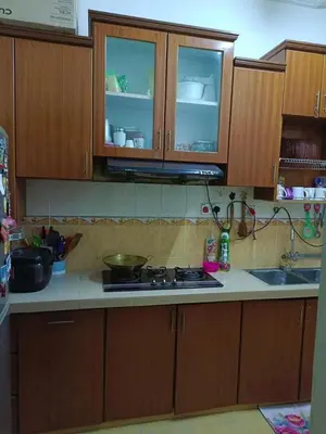 a kitchen with wooden cabinets and a stove top oven at Airis Homestay Bertam Perdana in Kepala Batas