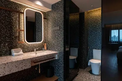 a bathroom with a sink and a mirror and a toilet at Break & Stay formerly known as BreakX Hotel in George Town