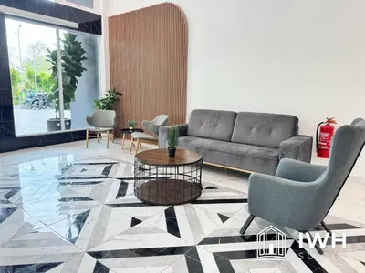 a living room with a couch and a table and chairs at ICC Ipoh Town Premium Suites By IWH Suites in Ipoh