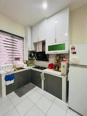 a kitchen with white cabinets and a refrigerator at Inap Kasih Homestay GM in Gua Musang