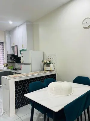 a kitchen with a white table and blue chairs at Inap Kasih Homestay GM in Gua Musang