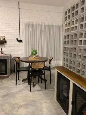 a dining room with a table and chairs and a fireplace at RumaTisa in Teluk Intan