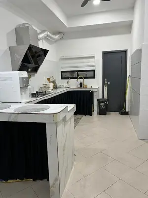 a large white kitchen with a large counter top at yasmins homestay in Sitiawan