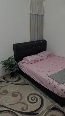a bedroom with a bed with a black headboard at Homestay KakCik Ah in Kepala Batas