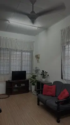 a living room with a couch and a flat screen tv at Homestay KakCik Ah in Kepala Batas
