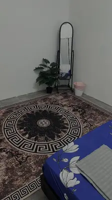 a room with a rug and a chair and a table at Homestay KakCik Ah in Kepala Batas