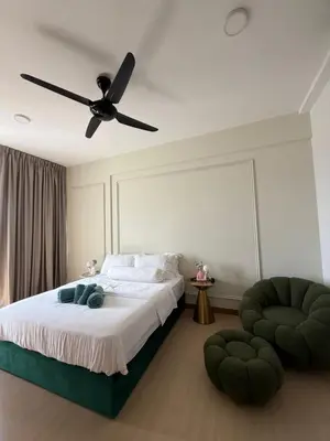 a bedroom with a bed with a ceiling fan at Macalister Suite - 2 bedrooms in Kampong Makam
