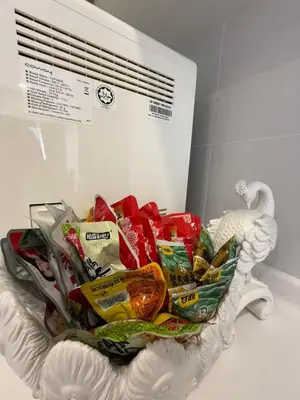 a bowl filled with chips and other food in front of a vent at Macalister Suite - 2 bedrooms in Kampong Makam