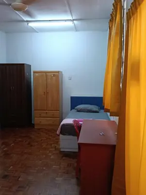 a room with a bed and a dresser in it at Homestay Jannati Bandar Baru Putra Ipoh in Ipoh