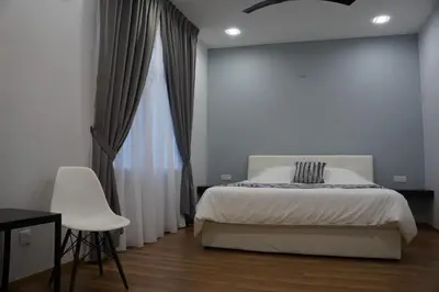 a bedroom with a bed and a chair and a window at Shamrock Boutique Villa - Stay for 12 person in Batu Ferringhi
