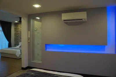 a room with a blue wall with a air conditioner at Shamrock Boutique Villa - Stay for 12 person in Batu Ferringhi