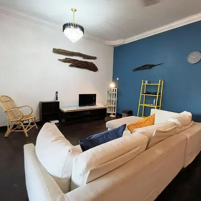 a living room with a white couch and a blue wall at TG103a Pet Friendly 15pax, near beach side in Tanjung Bungah