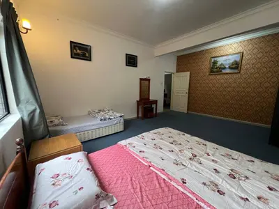 a bedroom with two beds and a pink blanket at Cottage Hill -Cameron Highlands in Cameron Highlands