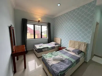 two twin beds in a room with a window at Cottage Hill -Cameron Highlands in Cameron Highlands