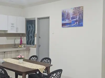 a table and chairs in a kitchen with a picture on the wall at Mikayla Homestay in Ipoh