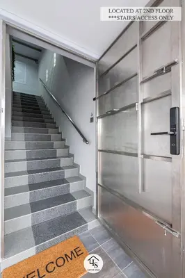 a staircase with a metal door and a stair runner at IPOH CAIP TownHouse UpperUnit 4R3B Ipoh Tambun 10Pax by Luvit Stay in Ipoh