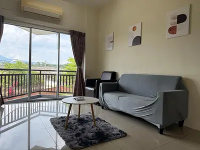 a living room with a couch and a table and a balcony at Bright Apartment in Klebang in Ipoh