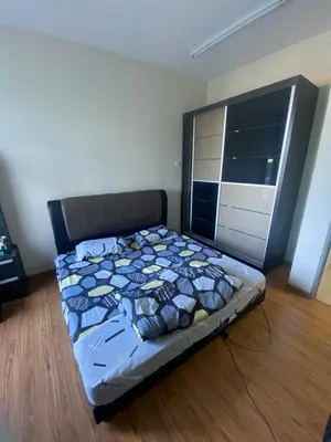 a bedroom with a bed with a blue comforter at Bright Apartment in Klebang in Ipoh