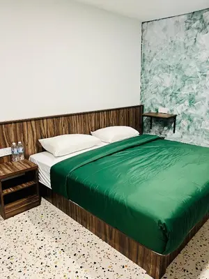 a bedroom with a large bed with a green blanket at Big Dreams Hotel in Tanah Rata