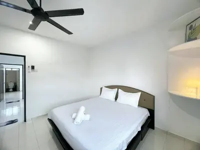 a bedroom with a white bed with a ceiling fan at Cozy living 2 Storey Haus 4Room10Pax-Near Icon City in Bukit Mertajam