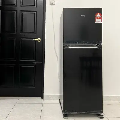 a black refrigerator next to a black door at Cozyhaus Ipoh in Ipoh