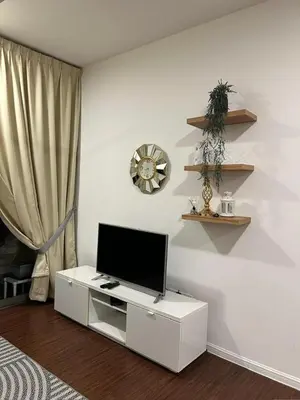 a living room with a television on a white cabinet at Ella Residence Homestay in Brinchang