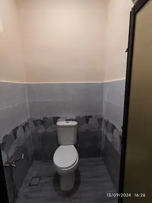 a bathroom with a white toilet in a room at Syakeel Homestay Bandar Bharu, Parit Buntar & Nibong Tebal in Bandar Baharu