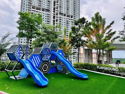 a playground with a blue slide on the grass at Home Away From Home in Penang in Jelutong