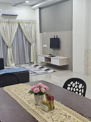 a living room with a table with flowers on it at Mikayla homestay in Ipoh