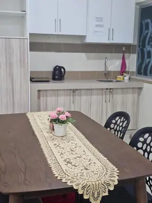 a wooden table with a pot of flowers on it at Mikayla homestay in Ipoh