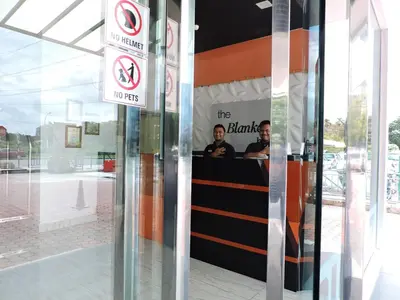two men are sitting in a sign in a building at The Blanket Hotel Seberang Jaya in Perai