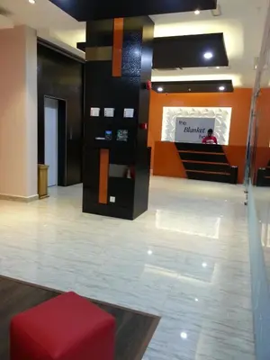 a lobby with a red ottoman in the middle at The Blanket Hotel Seberang Jaya in Perai