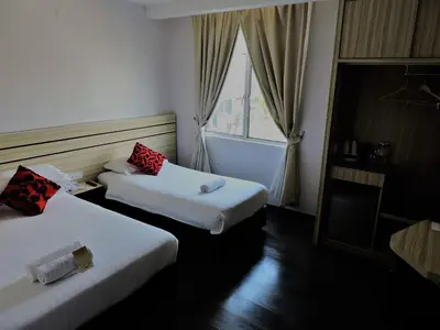 a hotel room with two beds and a window at The Blanket Hotel Seberang Jaya in Perai