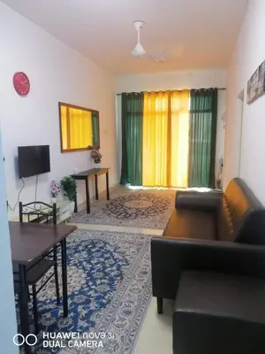 a living room with a couch and a table at Auni Homestay in Raub