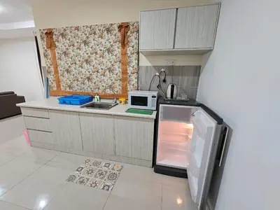 a small kitchen with a refrigerator and a microwave at Marina Island Apartment, Lumut in Lumut