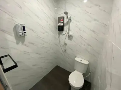 a white bathroom with a toilet and a phone on the wall at Rania Homestay Tasek Gelugor in Padang Chempedak