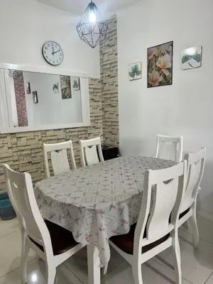 a dining room table with chairs and a clock on the wall at AYAAN BLOSSOM BUDGET HOMESTAY FREE WiFi and Netflix in Tanah Rata