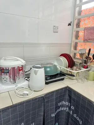 a kitchen counter with some dishes and a sink at AYAAN BLOSSOM BUDGET HOMESTAY FREE WiFi and Netflix in Tanah Rata