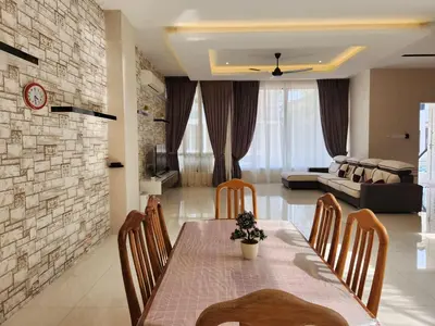 a dining room with a table and chairs and a living room at Botani Nadya 5B4B by verve 19 pax in Ipoh